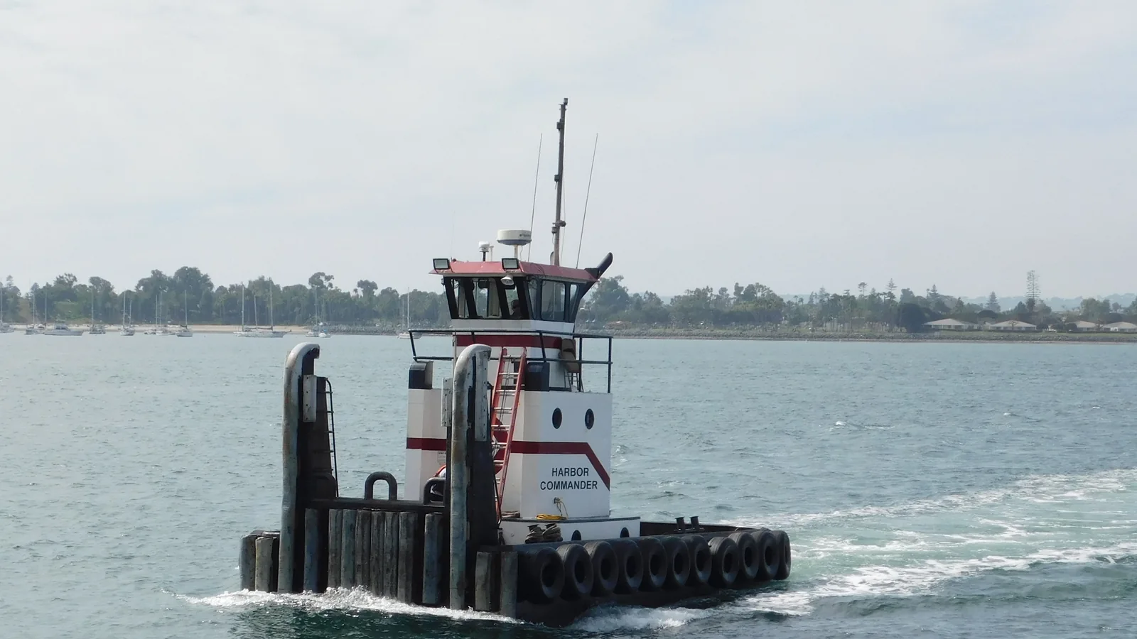 Working vessel and long shoreline across San Diego Bay